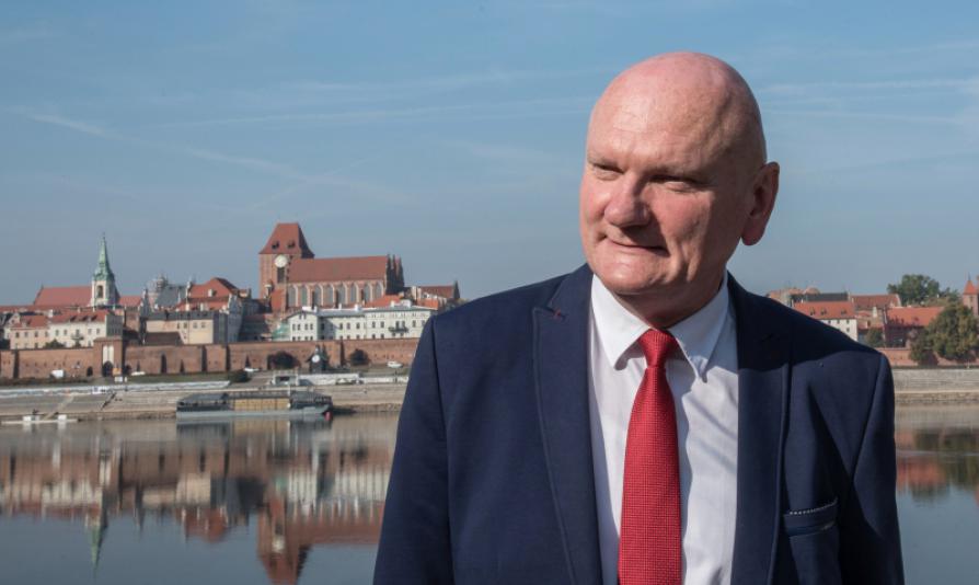 Zdjęcie Michała Zaleskiego - Prezydenta Torunia, w tle panorama miasta