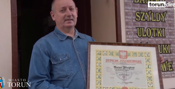 Pan Marian Wierzbicki - właściciel Toruńskiej Wytwórni Stempli - pozujący z dyplomem mistrzowskim przed swoim zakładem przy Placu Rapackiego 5 w Toruniu