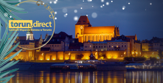 Logotyp CWB na tle wieczornej panoramy miasta Torunia