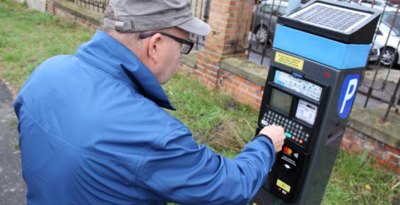 Na zdjęciu mężczyzna korzystający z parkomatu 