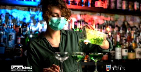 N a zdjęciu barmanka w maseczce higienicznej przygotowuje napoje